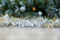 Christmas background with Christmas tree branches, blue and yellow layers and silver tinsel on a wooden background. Copy space for Royalty Free Stock Photo