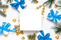 Christmas background white. White gift box with blue ribbon, New Year balls and Christmas tree in xmas composition on white Royalty Free Stock Photo