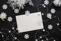 Christmas background: white snowflakes, white card  for congratulatory text and garland on the black background. Top view. Flat Royalty Free Stock Photo