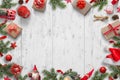 Christmas background on white wooden desk with Christmas tree, gifts, dolls, balls, Santa hat, candles, lantern, pinecones Royalty Free Stock Photo
