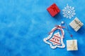 Christmas background. Christmas wooden bell, gifts box, snowflake on a blue background. Top view, copy space. Royalty Free Stock Photo