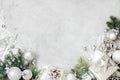 Christmas background with xmas decorations. Silver christmas present gift box, fir tree branch and baubles ornaments on gray stone Royalty Free Stock Photo