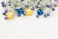 Christmas background with Xmas tree twig, golden stars, blue glass balls and berries on white snow Royalty Free Stock Photo