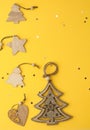 Christmas background from yellow paper with place for text, with wooden decorative Christmas tree decorations, stars and cinnamon Royalty Free Stock Photo