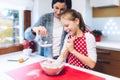 Christmas bakery. Mother and daughter making gingerbread, preparing eggs, flour and honey for gingerbread dough. Royalty Free Stock Photo