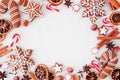 Christmas baking frame with cookies, peppermints and spices over a white marble background