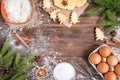 Christmas baking of ginger cookies on dark wooden background with fir branches