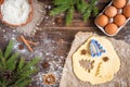 Christmas baking of ginger cookies on dark wooden background with fir branches