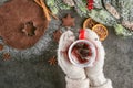 Christmas baking gingerbread with cup od tea in hands and ingredients, traditional christmas background from above