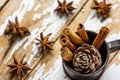 Christmas Baking Ingredients Decoration Cinnamon Sticks Scattered Anise Star Pine Cone in Vintage Jug on Snowy Wood Background.