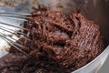 Christmas baking with raw chocolate dough in bowl and whisk. Holiday food concept, homemade child cookies and gingerbread. Close