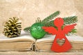 Christmas ball, fir-tree branch, red Angel, golden pinecone and old book