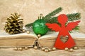 Christmas ball, fir-tree branch, red Angel, golden pinecone and old book