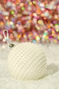 Christmas Ball nacre pearls on a snow and beautiful blurred colorful background of glittering bokeh with glowing lights.Soft focus Royalty Free Stock Photo