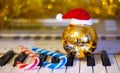 Christmas ball, Santa Claus hat and candy on piano keys for Christmas and New Year`s Eve_ Royalty Free Stock Photo