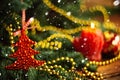 Christmas ball in shape of strawberry on a snow-covered tree branch. Red toy with frost and snowflakes. Selective focus Royalty Free Stock Photo