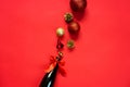 Christmas balls fly out of a bottle of champagne. Red background, New Years celebration. Decorations for the Christmas tree