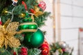 Christmas balls hanging on snowy fir tree. Many colorful balls garland glowing lamps and red berries on the branches are Royalty Free Stock Photo