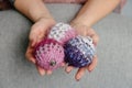 Christmas balls made of knitted threads in the hands of a girl, knitted Christmas toys