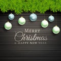 Christmas balls and pine tree leafs wooden background