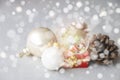 Christmas balls, Santa Claus in a Snow globe, and Pine cones on a white Cloth, set Against a Red Background and exquisite bokeh. Royalty Free Stock Photo