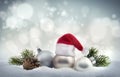 Christmas balls with Santa hat and fir twigs in the snow Royalty Free Stock Photo