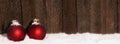 Christmas Balls in the snow in front of wooden background