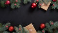 Christmas banner. Black Xmas background with red decorations, fir tree branches and gift boxes wrapped craft paper. Christmas Royalty Free Stock Photo