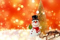 Christmas banner with bokeh and place for text. Snowman with wooden sleigh and Christmas tree on artificial snow with