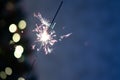 Christmas banner with copy space. Burning sparkler with bokeh light background. Sparks of sparkler on background of New Year`s