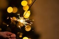 Christmas banner with copy space. Burning sparkler with bokeh light background. Sparks of sparkler on background of New Year`s