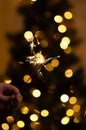 Christmas banner with copy space. Burning sparkler with bokeh light background. Sparks of sparkler on background of New Year`s