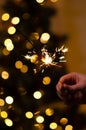 Christmas banner with copy space. Burning sparkler with bokeh light background. Sparks of sparkler on background of New Year`s