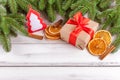 Christmas banner with green tree, giftbox, handmade felt decoration, orange and cinnamon on white wooden background Royalty Free Stock Photo