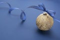 Christmas bauble with blue ribbon, isolated over blue background. Classic blue abstract background. Copy space