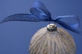 Christmas bauble with blue ribbon, isolated over blue background. Classic blue abstract background. Copy space Royalty Free Stock Photo