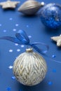 Christmas bauble with blue ribbon over blue background. Winter holidays greeting card. Classic blue