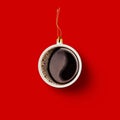 Christmas bauble decoration made of cup of coffee on red background. Minimal concept for Christmas or New Year