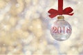 Transparent empty Christmas ball. Christmas bauble, hangs on a red ribbon on background of defocused silver lights. Royalty Free Stock Photo