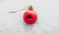 Christmas bauble in the snow, single red bauble