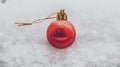 Christmas bauble in the snow, single red bauble