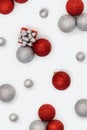 Christmas baubles decorations, red and silver colored balls and gift box New Year holiday pattern, flat lay. Royalty Free Stock Photo