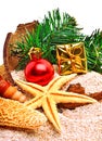 Christmas baubles, starfish, gift box and pine twig on the sand Royalty Free Stock Photo