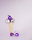 Christmas baubles vivid violet and metallic silver in ice cream cone.Disco 80s party design idea