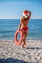 Christmas beach summer destination for Xmas holidays woman sunbathing going swimming with santa hat. Girl from behind Royalty Free Stock Photo