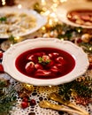 Christmas beetroot soup, borscht with small dumplings with mushroom filling in a ceramic white plate on a holiday table. Royalty Free Stock Photo