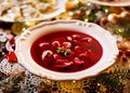 Christmas beetroot soup, borscht with small dumplings with mushroom filling in a ceramic white plate on a holiday table. Royalty Free Stock Photo