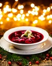 Christmas beetroot soup, red borscht with small dumplings with mushroom filling in a ceramic white plate on a wooden table. Royalty Free Stock Photo