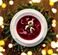 Christmas beetroot soup, red borscht with small dumplings with mushroom filling in a ceramic white plate on a wooden table Royalty Free Stock Photo