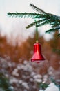 a Christmas bell on a branch of a fir tree. a branch of a fir tree with a Christmas toy on a blurry background is a New Royalty Free Stock Photo